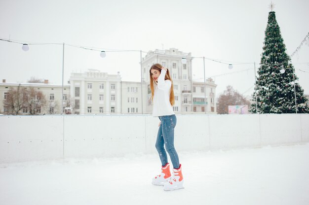겨울 도시에서 하얀 스웨터에 귀엽고 아름다운 소녀
