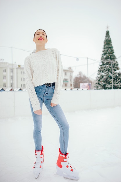 Милая и красивая девушка в белом свитере в зимнем городе