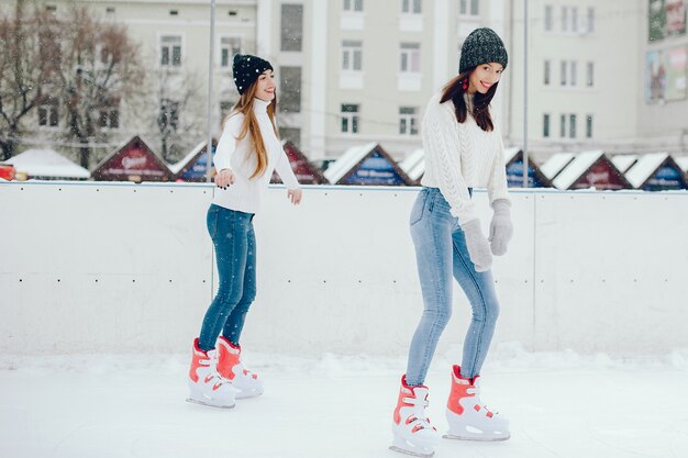 Cute and beautiful girls in a white sweater in a winter city