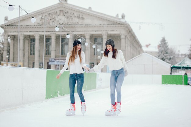 Cute and beautiful girls in a white sweater in a winter city