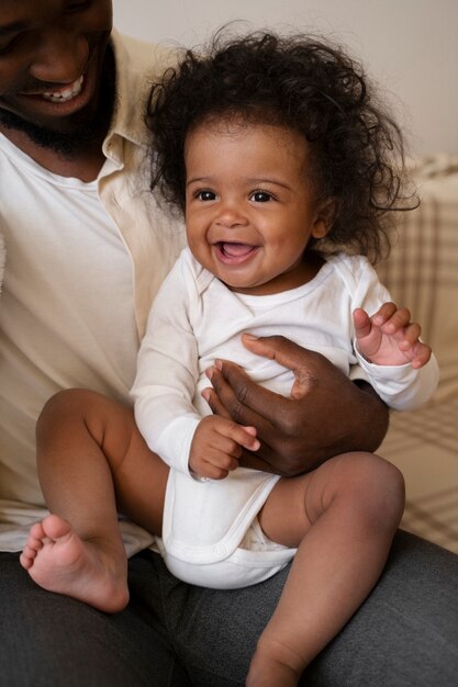 両親と一緒に家でかわいい黒人の赤ちゃん