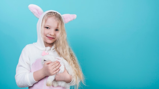 Cute blond girl in bunny ears with rabbit 