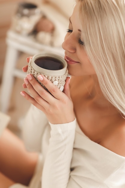 cute blond woman in cozy wear at home