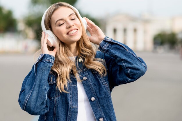 Милая блондинка девушка слушает музыку