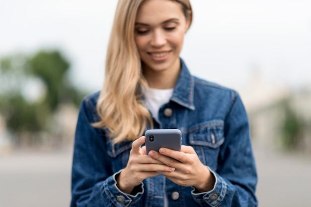 Cute blonde girl using her mobile phone