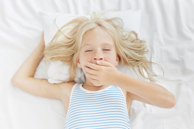 Cute blonde little girl in bed