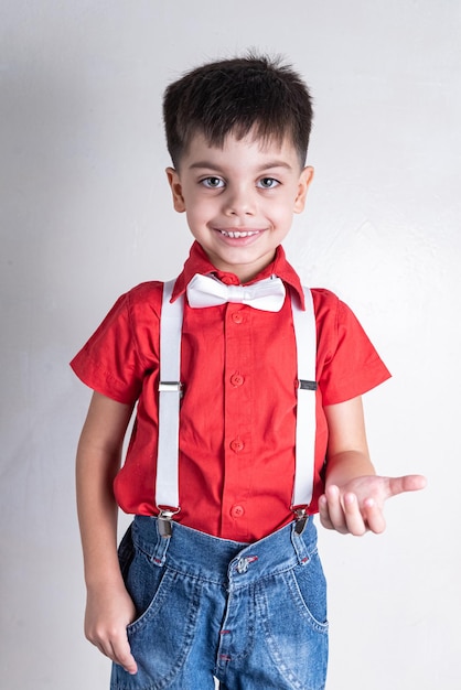 Cute boy in classic clothes on white background