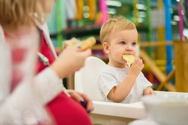 Free photo cute boy eating pizza