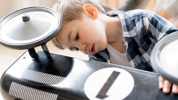 無料写真 かわいい男の子が彼のお気に入りの車のおもちゃを修正