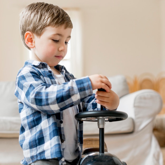 Free photo cute boy fixing his race car