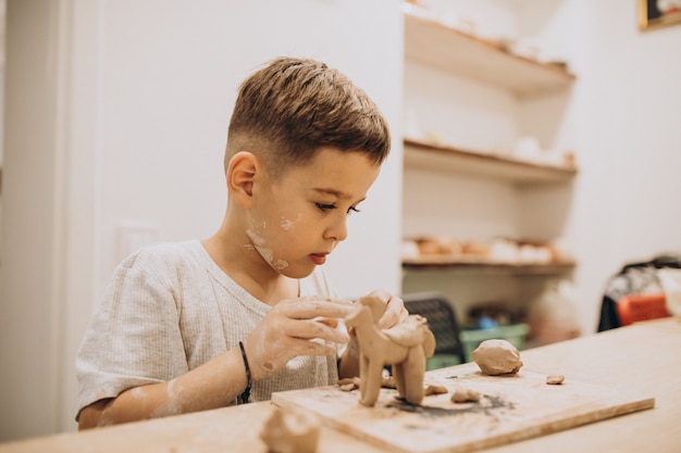 Cute boy forming toys from clay