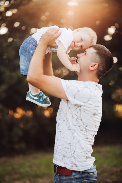 Cute boy and his father in park.