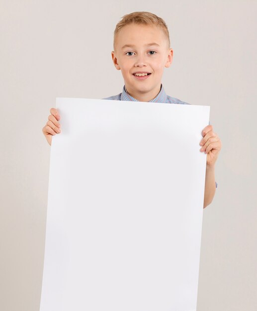 Cute boy holding empty paper