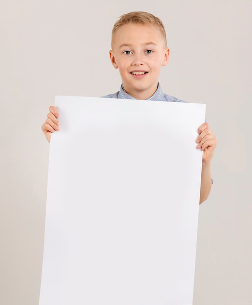 Cute boy holding empty paper