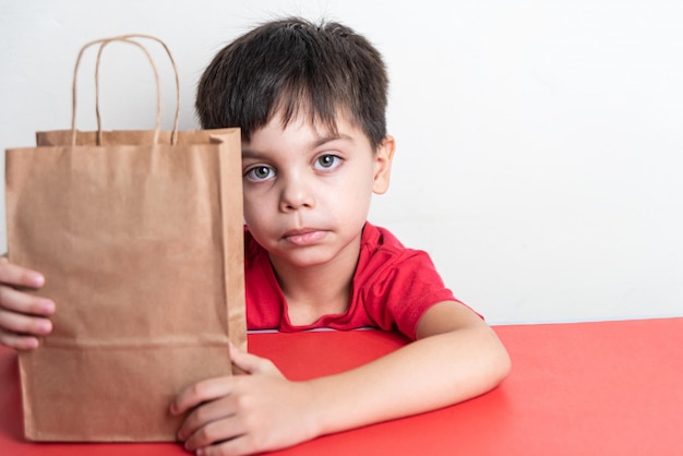 Free photo cute boy holding fast food shopping bag