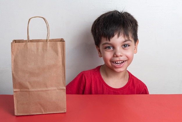 Free photo cute boy holding fast food shopping bag