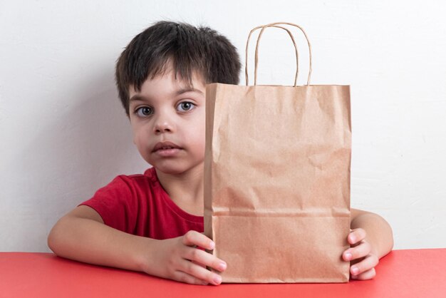 Free photo cute boy holding fast food shopping bag