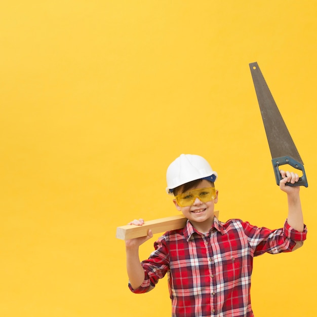 Cute boy holding saw tool copy space