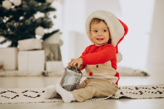 無料写真 クリスマスにサンタの帽子のオープニングプレゼントのかわいい男の子