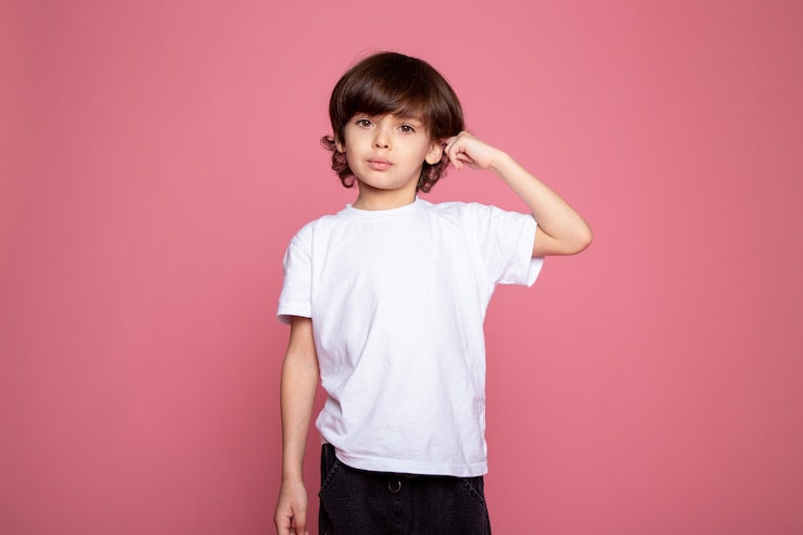 無料Photo ピンクの机の上の白いtシャツとブルージーンズの肖像画の小さなかわいい男の子