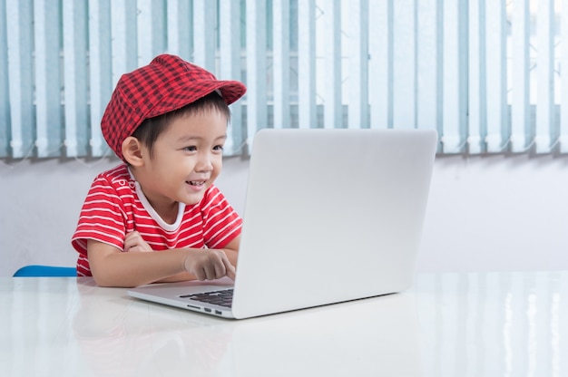 Cute boy playing labtop in the children's room