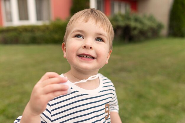 Cute boy playing with bubble blower