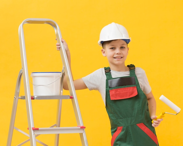 Free photo cute boy posing with ladder