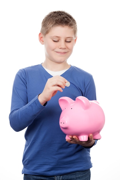 Free photo cute boy saving money in a piggybank