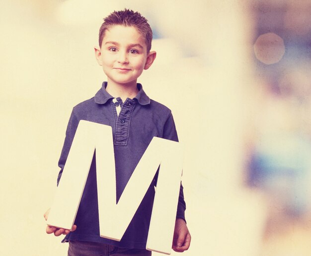 Cute boy showing the letter m