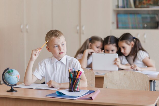 Cute boy thinking at lesson