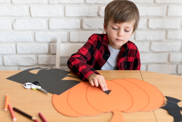 Foto gratuita ragazzo carino con il concetto di zucca di halloween