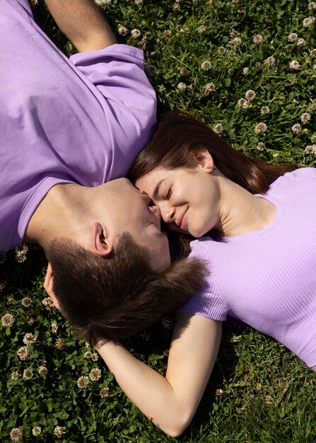 Cute boyfriend and girlfriend lying on grass