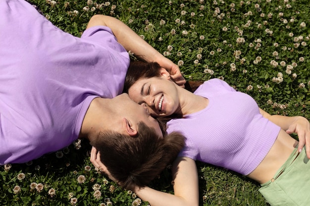 Cute boyfriend and girlfriend lying on grass