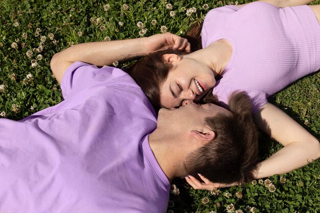 Cute boyfriend and girlfriend lying on grass