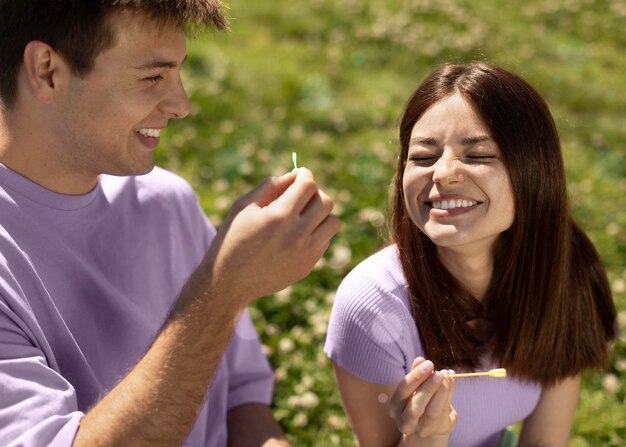 Cute boyfriend and girlfriend playing with soap bubbles