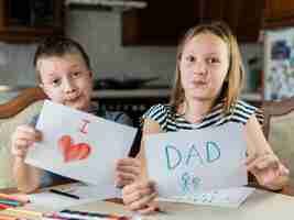 Free photo cute brother and sister drawing for father's day