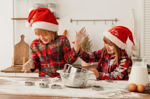 Foto gratuita fratelli carini che producono biscotti insieme