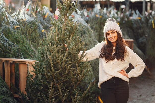 Cute brunette in a white sweater with Christmas tree