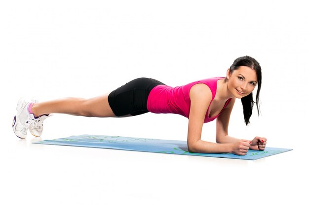 Cute brunette woman on the exercise mat