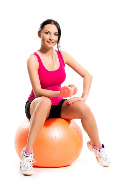 Cute brunette woman sitting on the ball