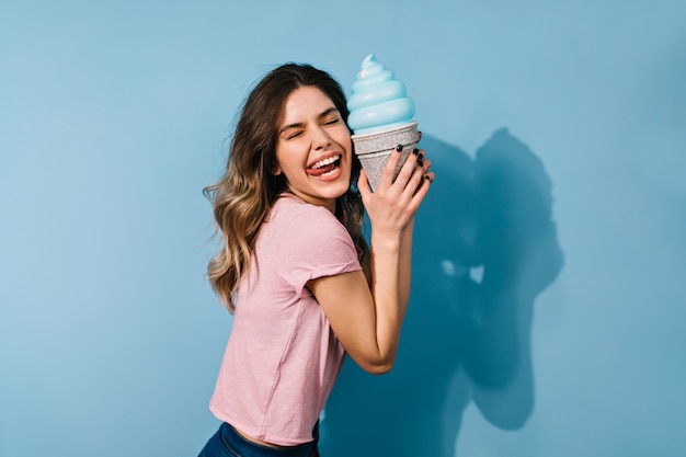 Cute brunette woman in t-shirt posing with ice cream