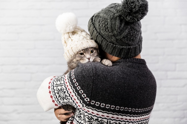 Free photo cute cat with hat held by owner