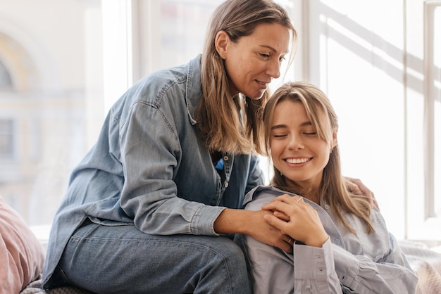 Free photo cute caucasian adult woman hugging her young daughter when they meet at weekend. concept of expressing love to loved ones