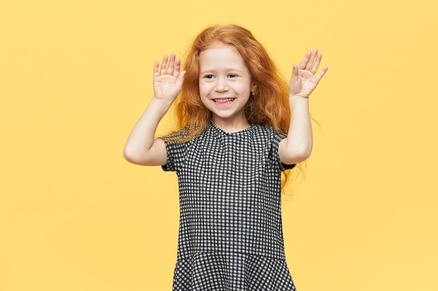 Free photo cute charming european little girl in elegant dress dancing to music, feeling free