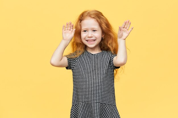 Cute charming European little girl in elegant dress dancing to music, feeling free