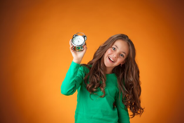 cute cheerful little girl on orange