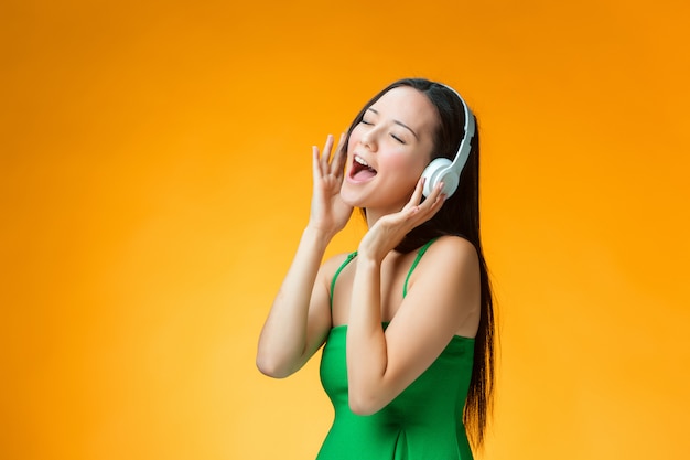 The Cute Cheerful Woman on Orange Wall – Free Stock Photo