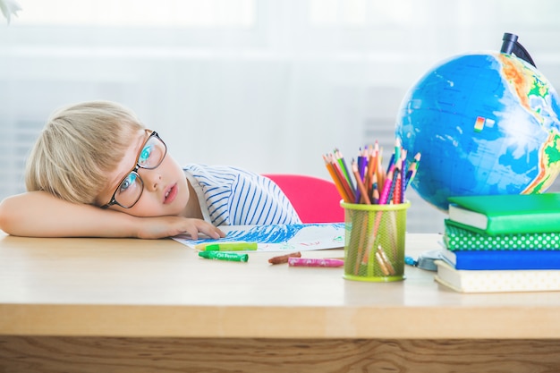 Cute child boring on the lesson. kid doesn`t want to do homework ...