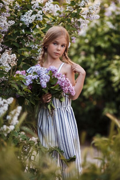 Милая девочка на открытом воздухе с букетом цветов