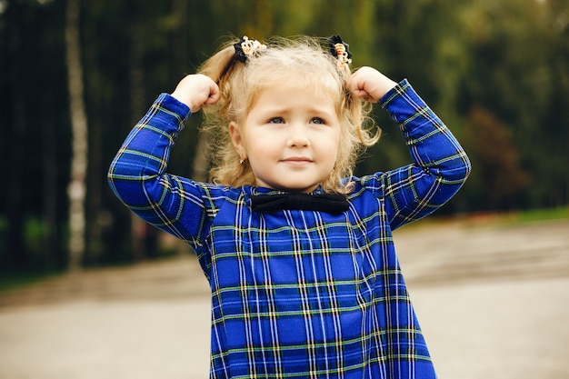 Free photo cute child in a park playing on a grass